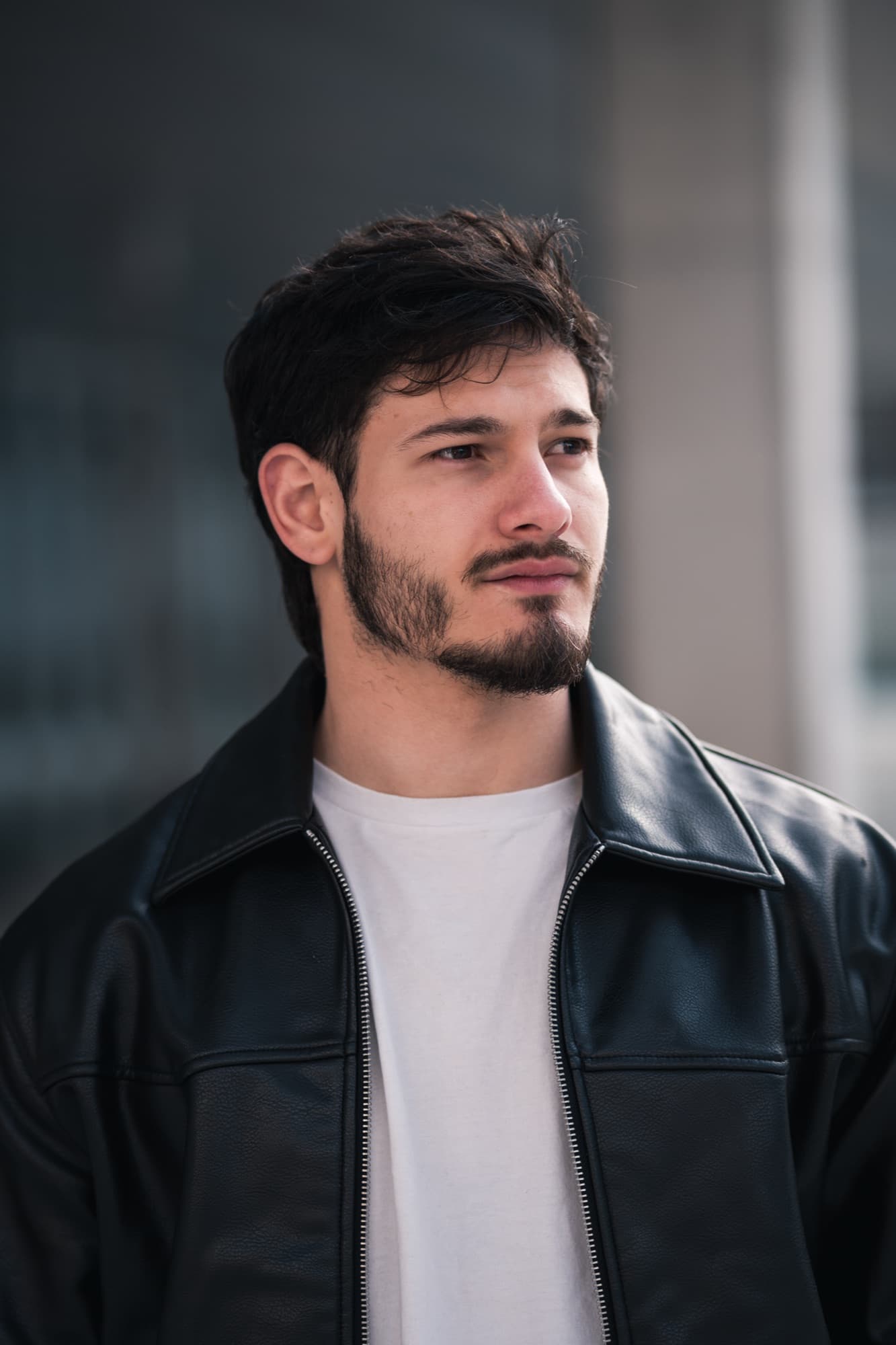 Retrato de día con campera de cuero frente a un edificio