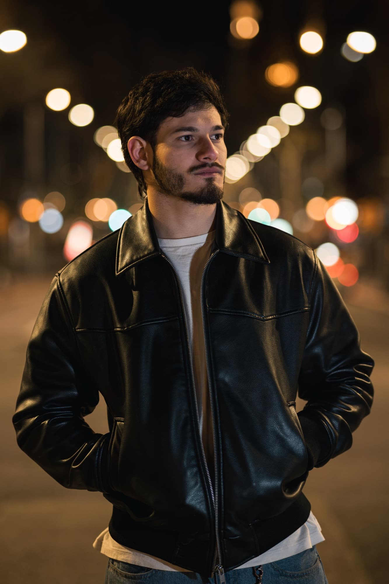 Retrato nocturno en la calle con luces desenfocadas de fondo