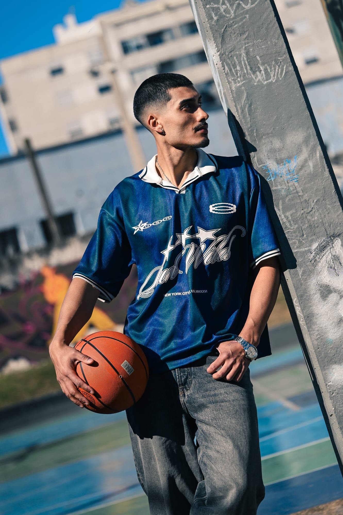 Retrato de perfil con una pelota de básquet, mirando hacia el sol en la cancha